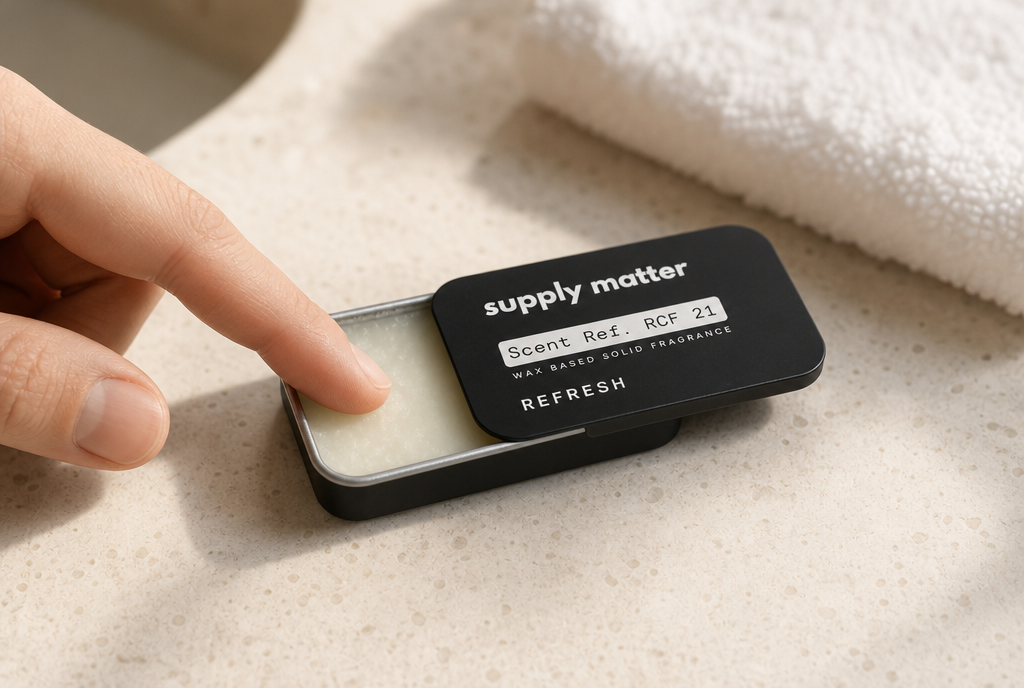 Applying Supply Matter solid cologne with a fingertip